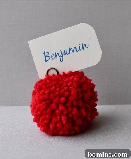 10 Ways to Add Pom-Pom Power to Your Decor & Crafts 9 Giant pom-pom place card holder with a name tag, adding a touch of whimsy to any table setting.