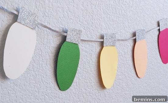 A paper decoration in the likeness of colorful Christmas lights. A close-up of a DIY Christmas light garland.