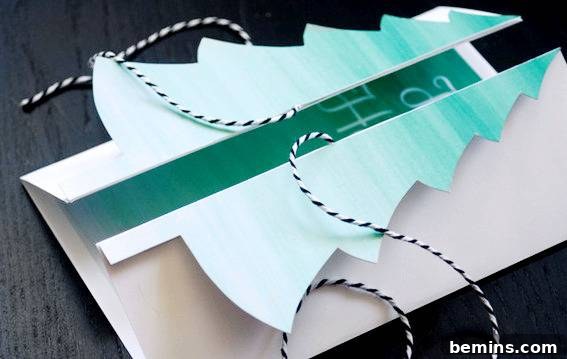 DIY Christmas Tree Card Tutorial Free Template 8 Greeting card with folded Christmas tree design interlaced with striped string, demonstrating alternative tying methods.