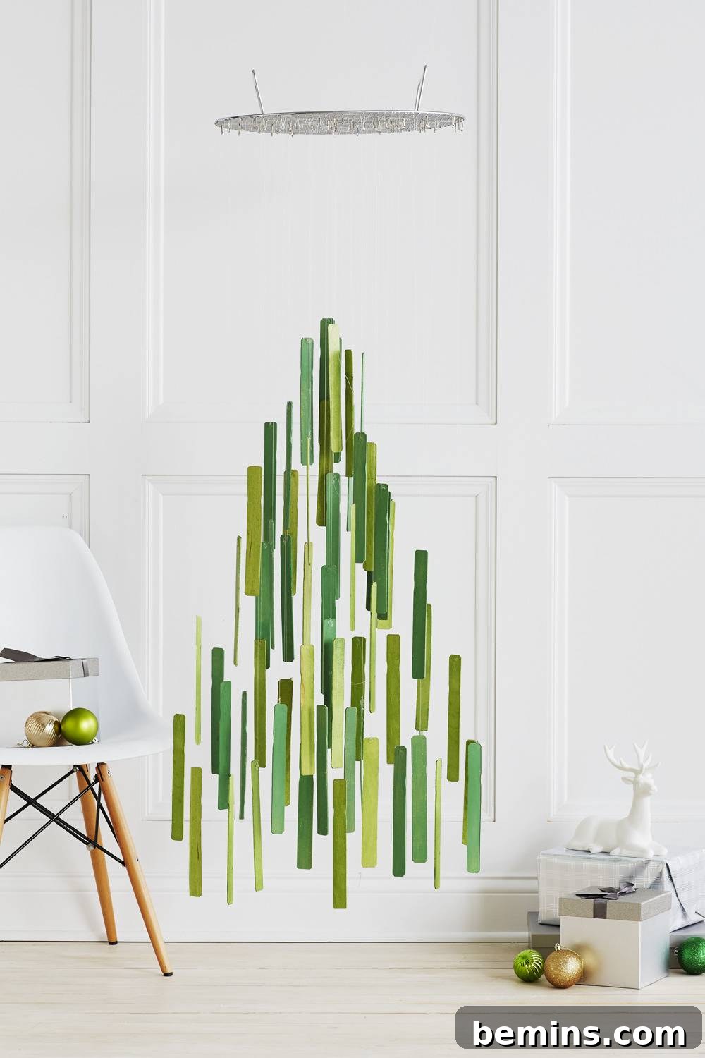 Creating a Chic DIY Christmas Tree Mobile 4 Strips in different shades of green that are hanging from a mobile in the shape of a tree.