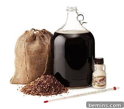 The Ultimate Gift List for Craft Lovers & DIYers 11 A glass growler filled with dark liquid, alongside a canvas bag and a pile of grain, representing the Vermont Maple Porter beer brewing kit.