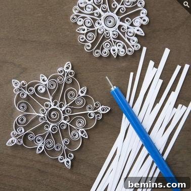 The Ultimate Gift List for Craft Lovers & DIYers 9 A blue pen and white sticks are positioned near snowflake crafts, showcasing the Whimseybox quilled snowflake kit.