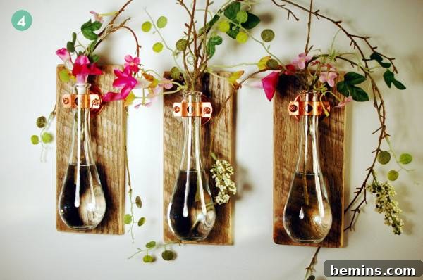 Three glass vases attached to wooden boards hanging on a wall