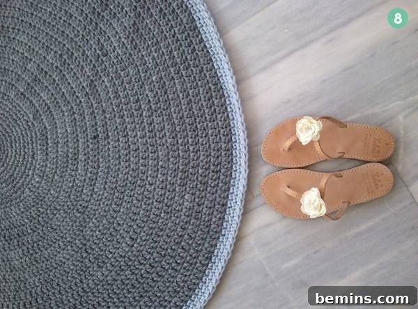 A pair of sandals sits by a round blue rug