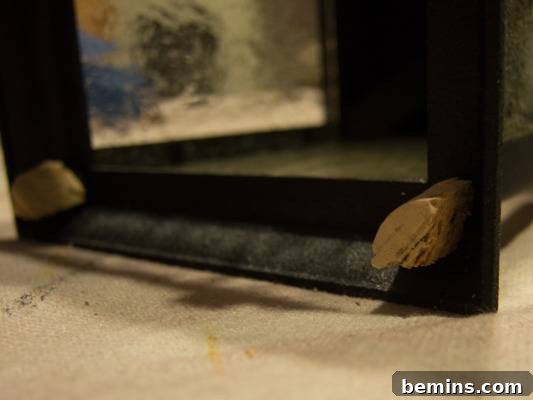 A black frame with brass in the corners. Close up of the cork feet attached to the lantern.