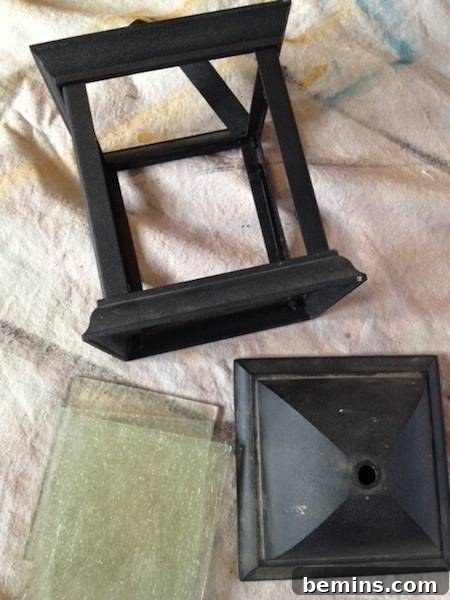 Pieces of a lantern are disassembled on a dirty piece of fabric. Before cleaning.