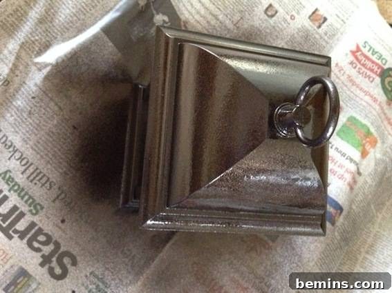 Top of metal lantern on top of open newspaper. Illustrates the painting process.