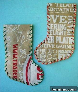 Two stockings made from recycled paper bags, adorned with lettering, displayed on a blue surface, highlighting a creative and eco-conscious approach to holiday decorating.