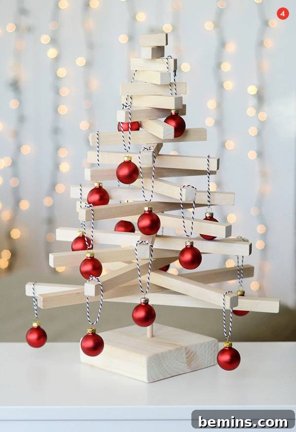 Creative Christmas: 10 Unique Tabletop Tree Alternatives 6 Christmas tree decoration made from white wood slats with red ball ornaments.
