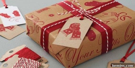 A Christmas present has been wrapped with twine over the ribbon and a large gift tag.