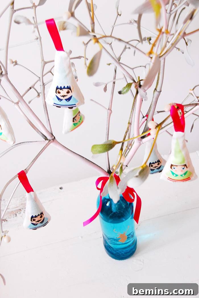 Hanging ornaments decorate branches that are coming out of a bottle.