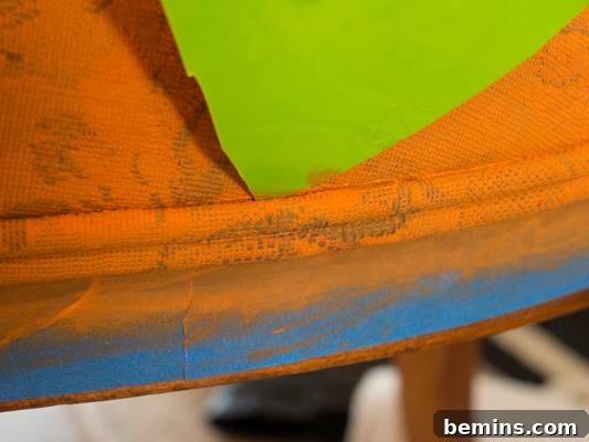 Using a plastic tool to remove excess paint from the trim.
