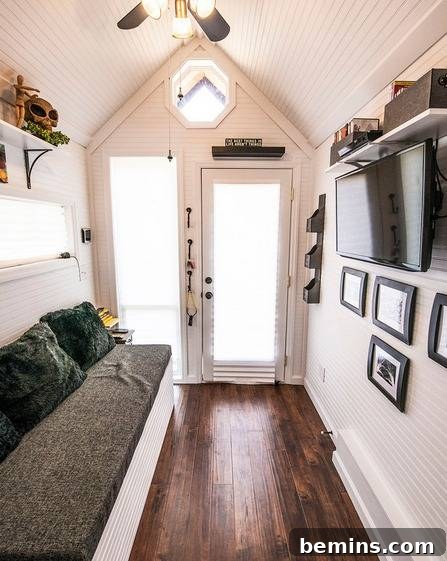 Eye Candy: 11 Tiny Homes That Will Steal Your Heart 4 Tiny home interior with couch, TV, and photo frames