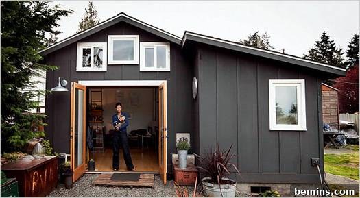 Eye Candy: 11 Tiny Homes That Will Steal Your Heart 7 Woman standing in the doorway of a tiny home