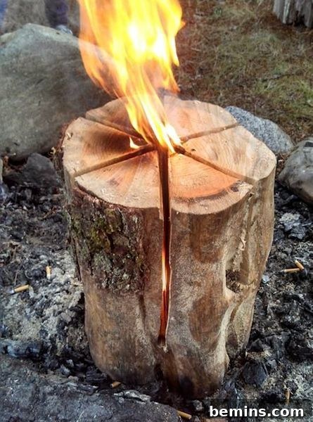 A Swedish Fire Torch burning brightly, showcasing its vertical flame and split log construction.