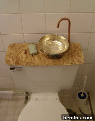 How to Repurpose Your Toilet Tank into a Sink 2 A toilet in the bathtub with a faucet and sink on top of it. Space-saving bathroom idea.