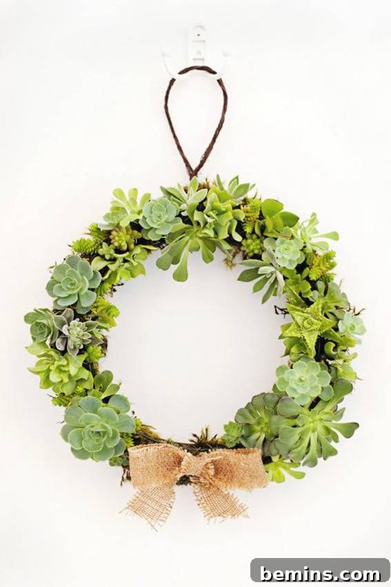 A wreath with a tan bow hanging on a white wall