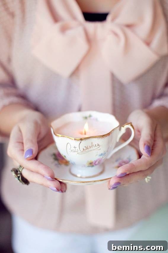 A woman holding a teacup and saucer with a candle inside