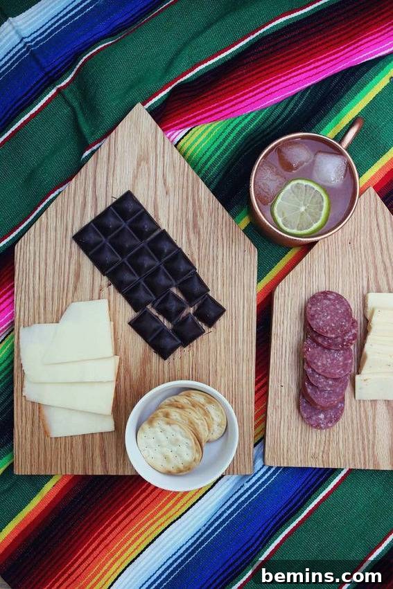 Cheese, crackers, and salami on wooden cutting boards