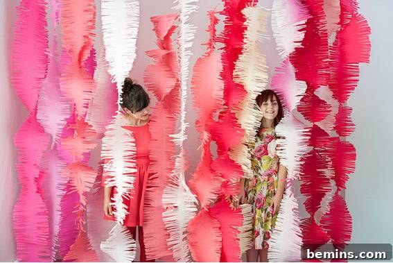 Two kids are standing behind the decorative papers.