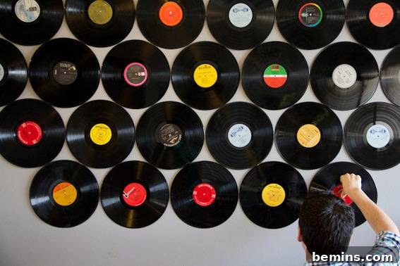 Man hanging records onto a wall.