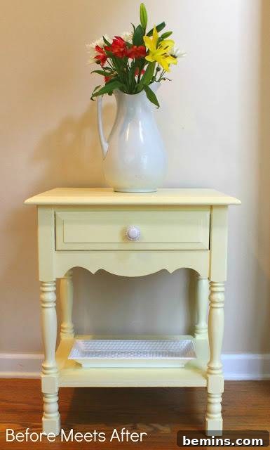 After: A beautifully restored side table with yellow paint, adorned with flowers