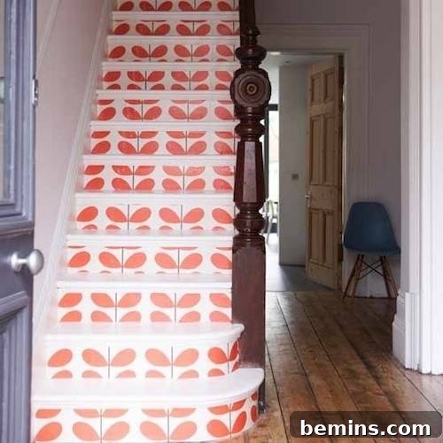 Entryway to stairs with colorful wallpaper featuring orange leaves on the risers