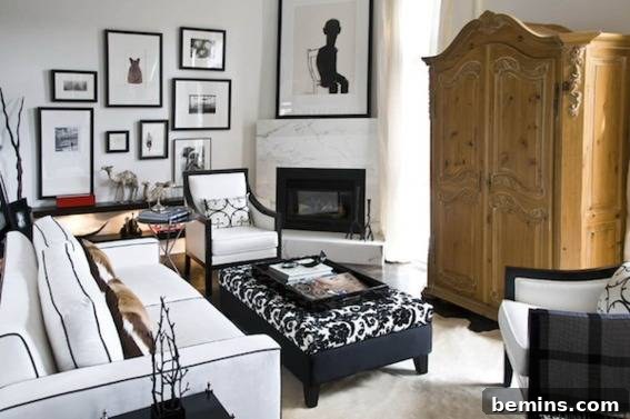 Living room with wooden cupboard, frames, tables, sofas, and cushions showcasing neutral art