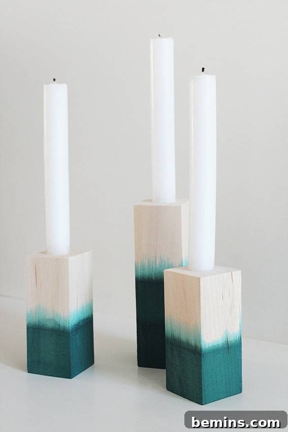 White candles in white and blue wooden brick holders.