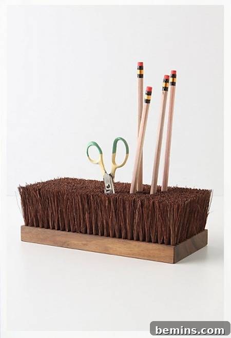 Pencils and scissors stored in a repurposed broom head