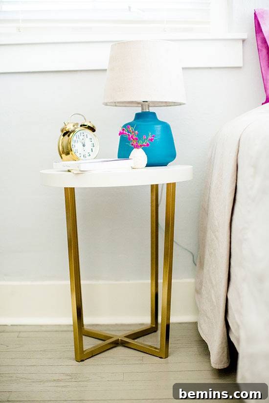 Lampl and clock is on the table beside bed.