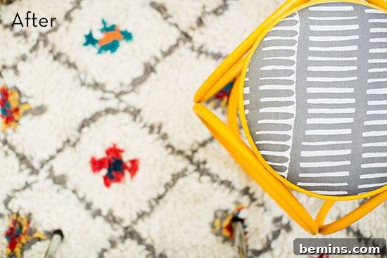 Vintage Footstool Transformation: A Stylish Redo 3 A yellow stool with a grey and white patterned cushion on a white rug with colorful square designs.