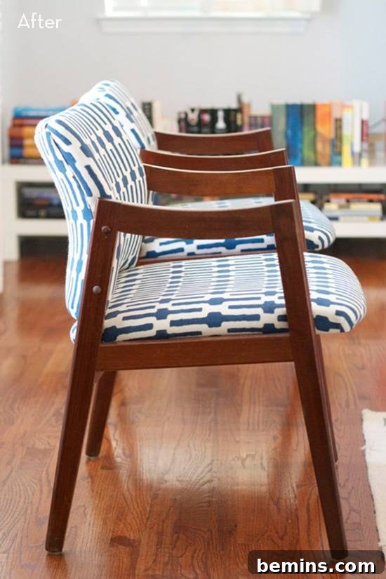 Blue and white chair with wooden arms and legs on a wooden floor.