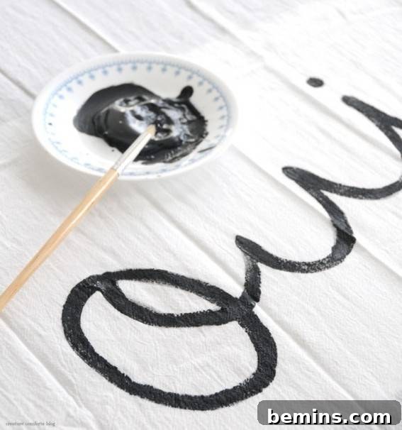 14 Textile DIYs to Level Up Your Craft Game 9 A white table displaying black paint in cursive writing, adding a personalized and artistic touch.