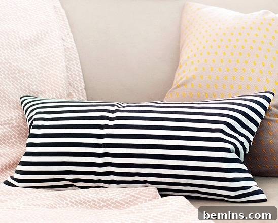 A bed with a black and white striped no-sew pillow.