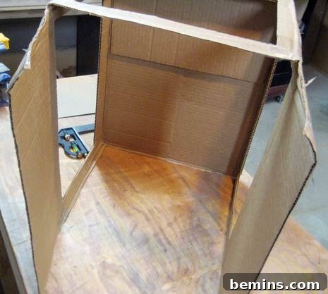 Cardboard box with the sides and top partially cut out for a DIY light box.