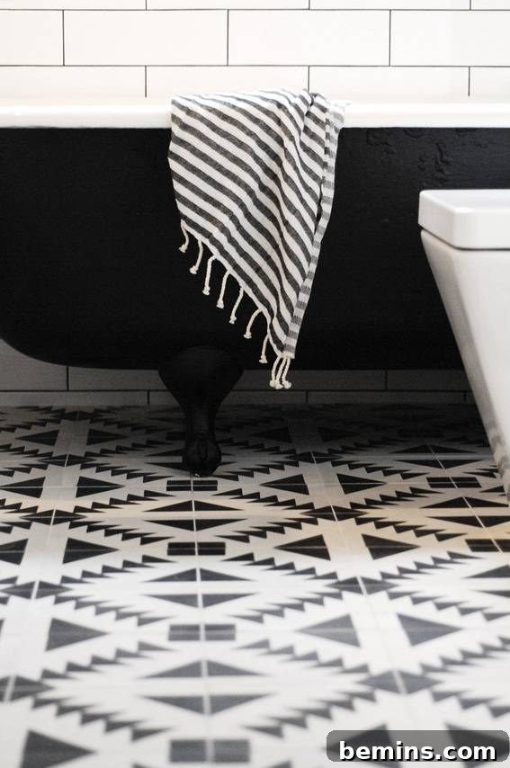 Statement Piece: A Black Bathtub Takes Center Stage on a Stylish Patterned Floor