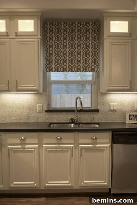 A sink is set into a white cabinet under the window.