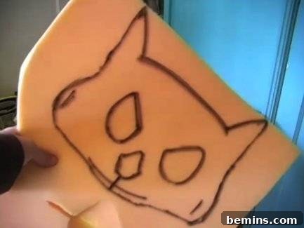 A cat is drawn on a yellow material a child is holding.