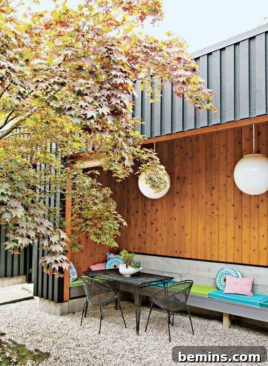 A black colour metal table and 2 chairs are lying in the backyard of a house.