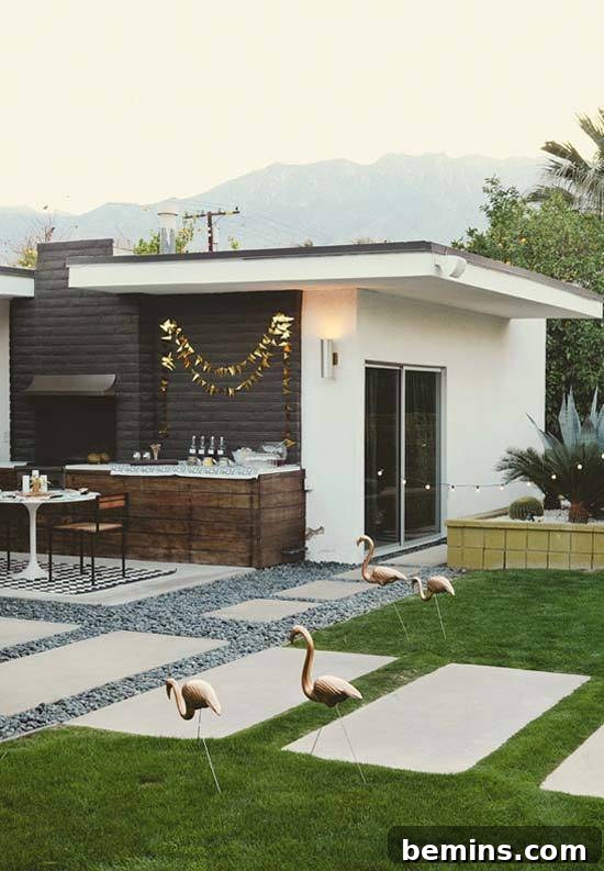 A modern white home has a lawn with large concrete walking blocks on it.