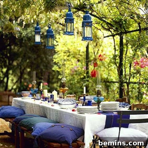 Outdoor Kitchen Dreams: 12 DIY Spaces to Inspire 13 Blue and white pillows sit on stools set up at a table prepared for a garden party.