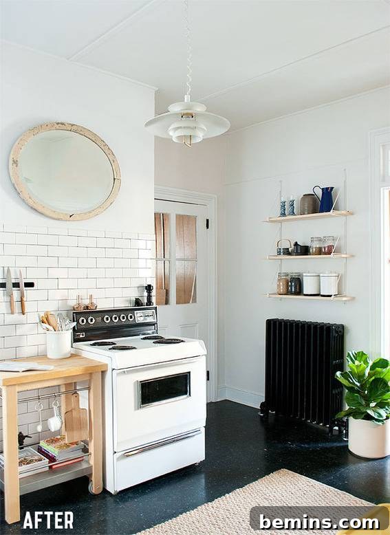 A stylish black and white kitchen, featuring classic subway tiles, a modern stove, an organized spice rack, and a large mirror that reflects light and expands the space.