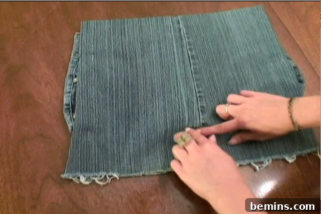 Adjusting the denim flap inside the jean purse, preparing it for attachment.