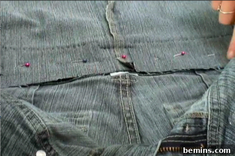 Attaching the denim flap to the body of the jean purse with a sewing machine.