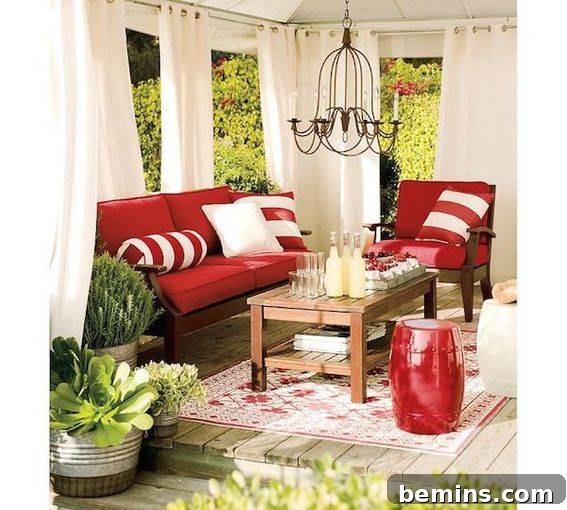 A stylish living room with a red sofa, red and white pillows, a red chair, and tall white curtains creating an elegant ambiance.