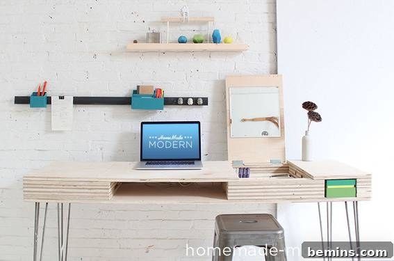 A computer sits on a wooden desk in a white brick room.