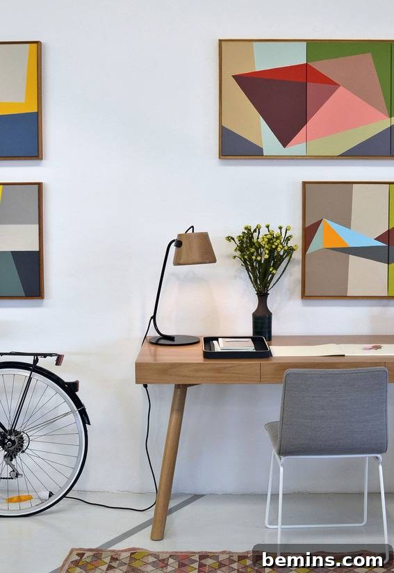Visually Stunning: 17 Inspiring Workspace Designs 13 An office with many abstract pictures, a clean work area, and a bike.