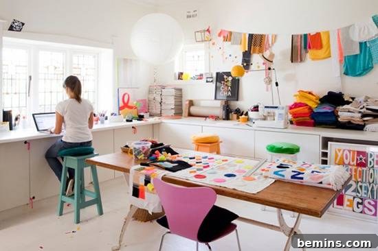 Visually Stunning: 17 Inspiring Workspace Designs 16 "Laddy sitting on stool with a laptop in crafting room."