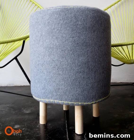 Stylish Seating: 12 DIY Stool and Bench Projects 11 Tall grey, round seat, with small wooden peg legs; in front of two green yarn chairs.